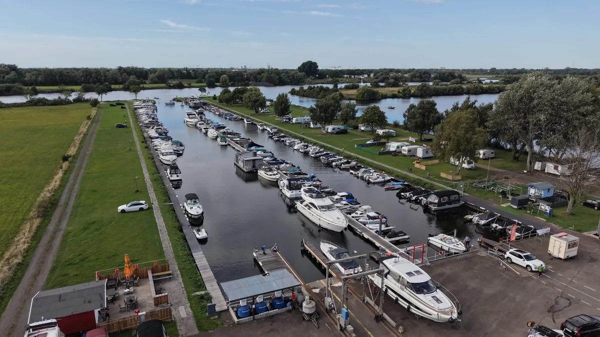 Luftaufnahme über dem Hafenlift: im Vordergrund eine Motoryacht an Land, dahinter die Stege und die Weser