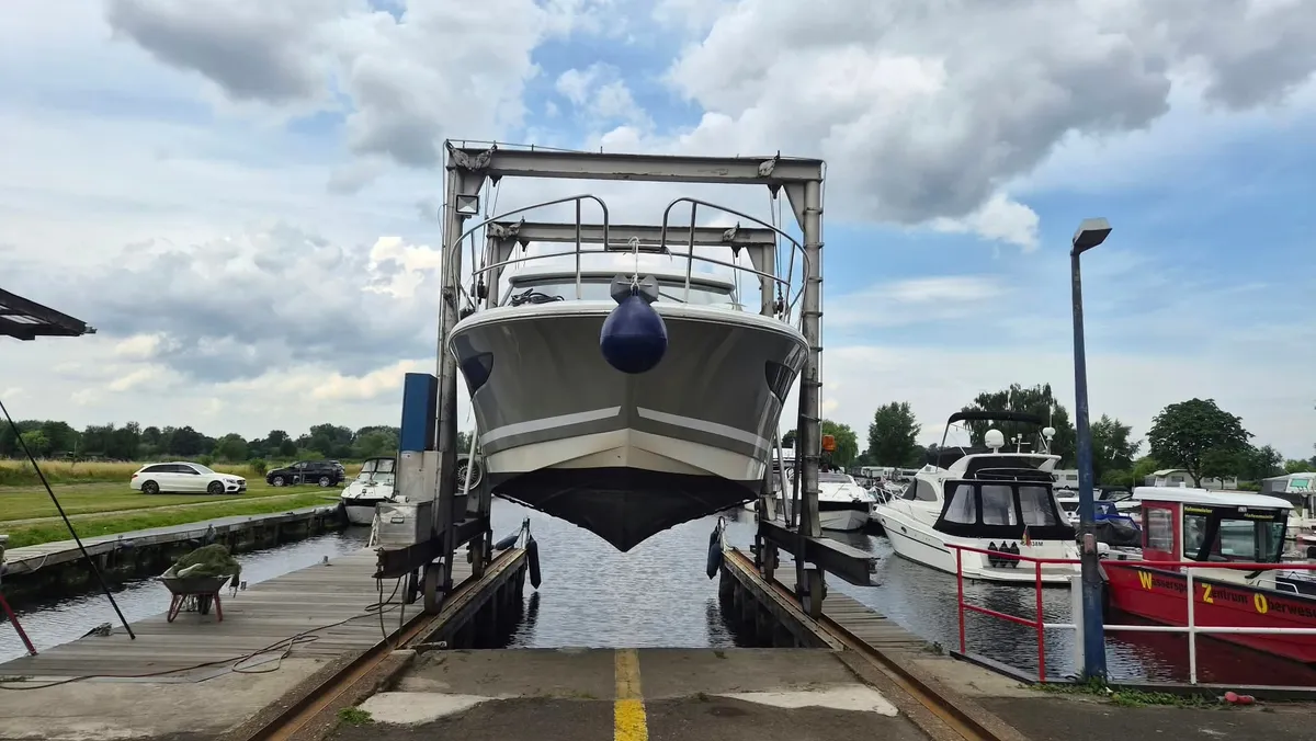 Der Hafenlift im Wassersport-Zentrum Oberweser hebt eine Motoryacht in Gurten aus dem Hafenbecken